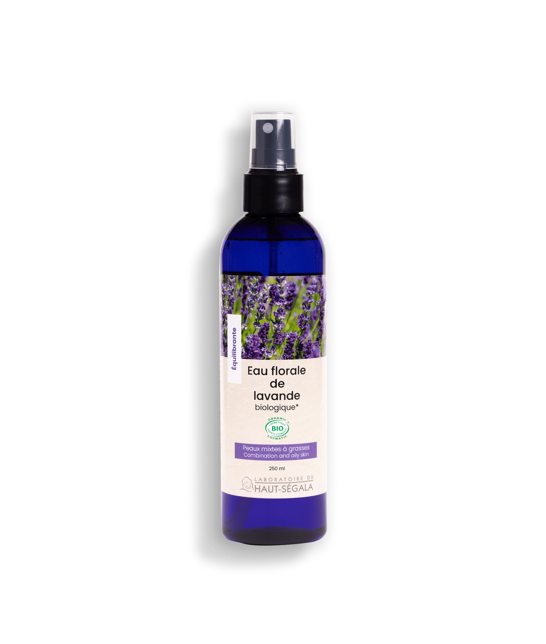 Une bouteille en spray bleue de "LABORATOIRE DU HAUT-SÉGALA Eau florale de lavande biologique" est posée sur un fond transparent. L'étiquette violette et blanche indique "Équilibrante", "Peaux mixtes à grasses", "250 ml", et le logo "BIO COSMOS ORGANIC". L'image représente une eau florale lavande bio et un hydrolat lavande équilibrante pour les peaux mixtes à grasses.