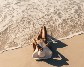 Femme allongée sur la plage après une exposition au soleil, symbolisant la détente et le besoin d'apaiser la peau.