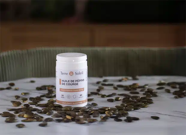Pilulier de complément alimentaire huile de pépins de courge Terre & Soleil sur fond de graines