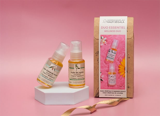 Deux flacons d'huiles végétales (amande douce et jojoba) du Duo Essentiel biologique du Laboratoire Haut-Ségala, posés à côté de leur emballage.